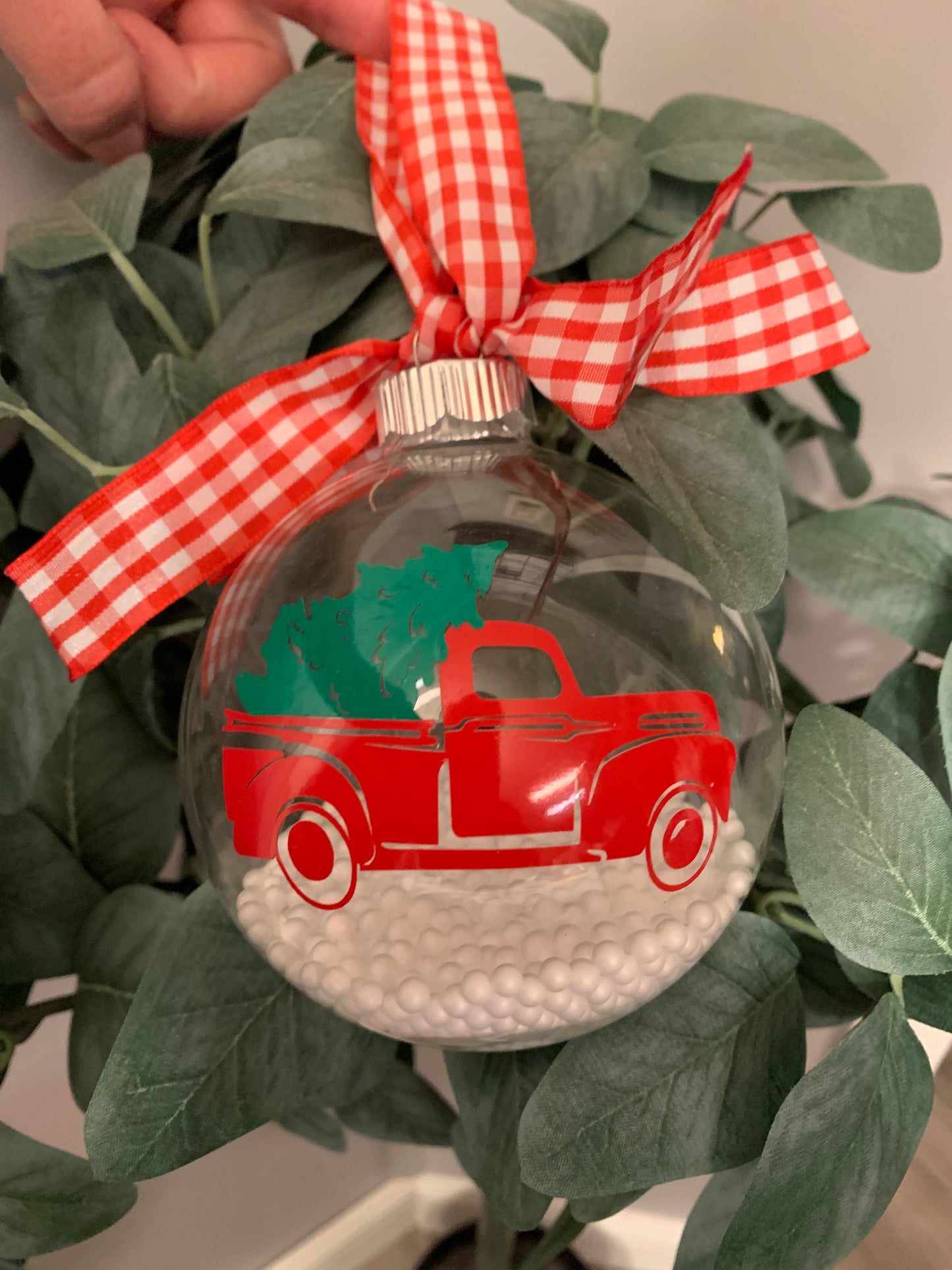 Large glass ornament of red truck with tree.